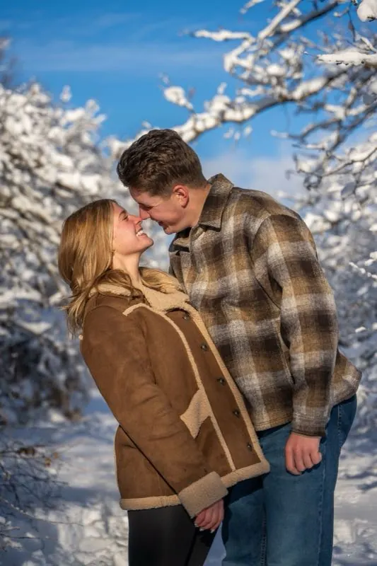 Couple kissing against a bright blue winter sky